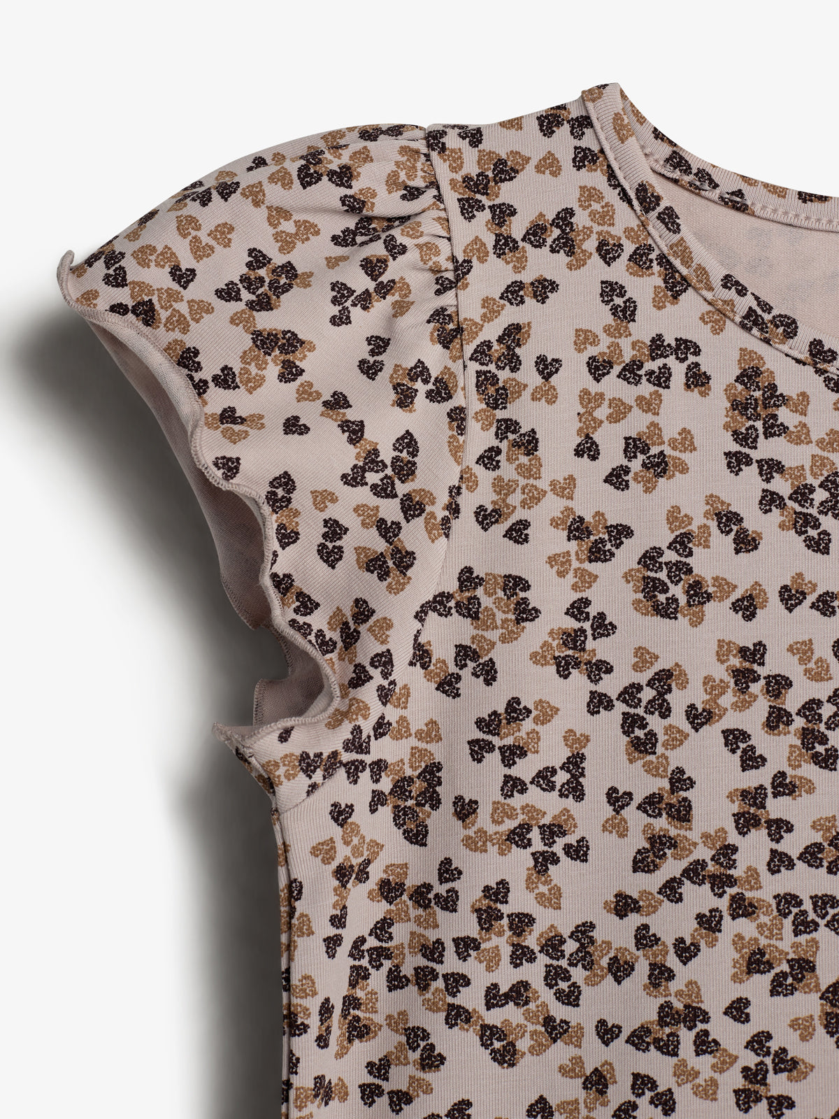 A beige shirt with puffed sleeves, featuring a pattern of small black and brown butterflies. The fabric has a textured appearance, and the focus is on the sleeve detail.