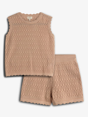 A knitted sleeveless top and shorts set in a beige color. The top features a diamond and zigzag pattern, alongside scalloped edges. It's laid on a plain light background.