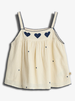 Cream-colored tank top adorned with dark blue heart embroidery and scalloped trim, hanging flat against a plain white background.