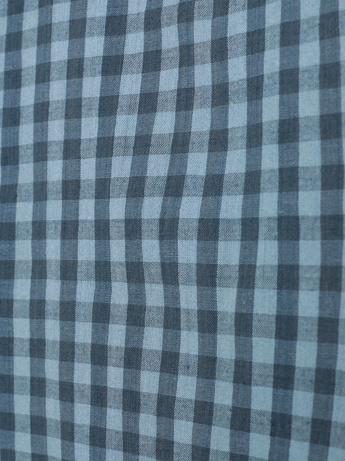 Checkered fabric consists of alternating dark and light blue squares, arranged in a grid pattern. The surface appears smooth, without additional context or objects visible around it.