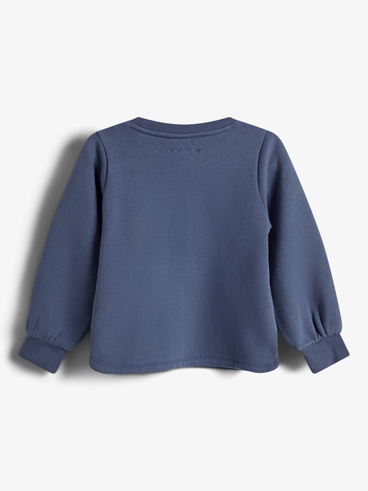A blue long-sleeve shirt is hanging against a white background, displaying a simple design with ribbed cuffs and slight embroidery on the back.