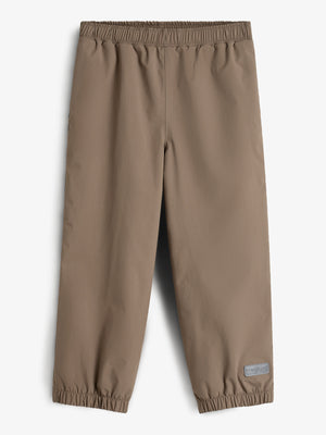 Brown elastic-waist pants with cuffed hems lay flat against a plain background. A small rectangular label with text "FORMATUM" is on the lower right leg.